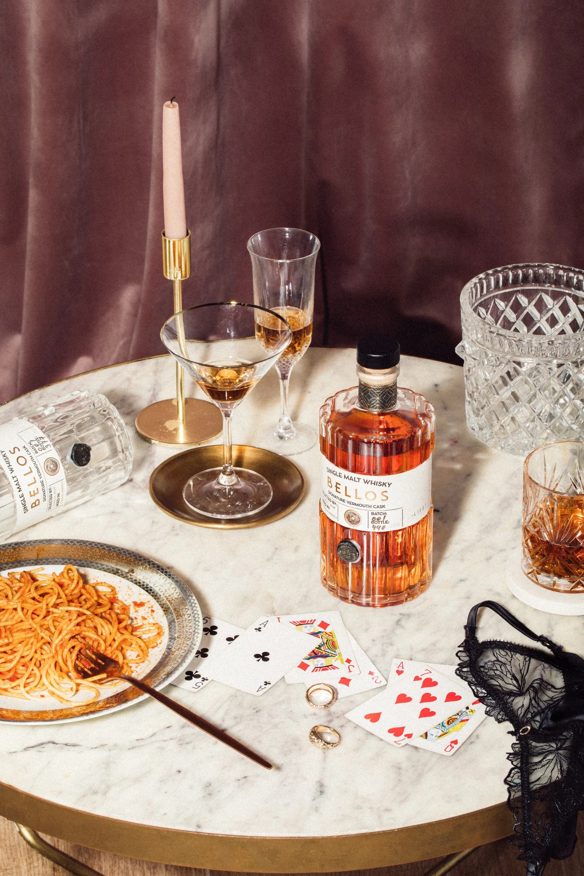 Bellos whisky sobre mesa de mármol con cartas
