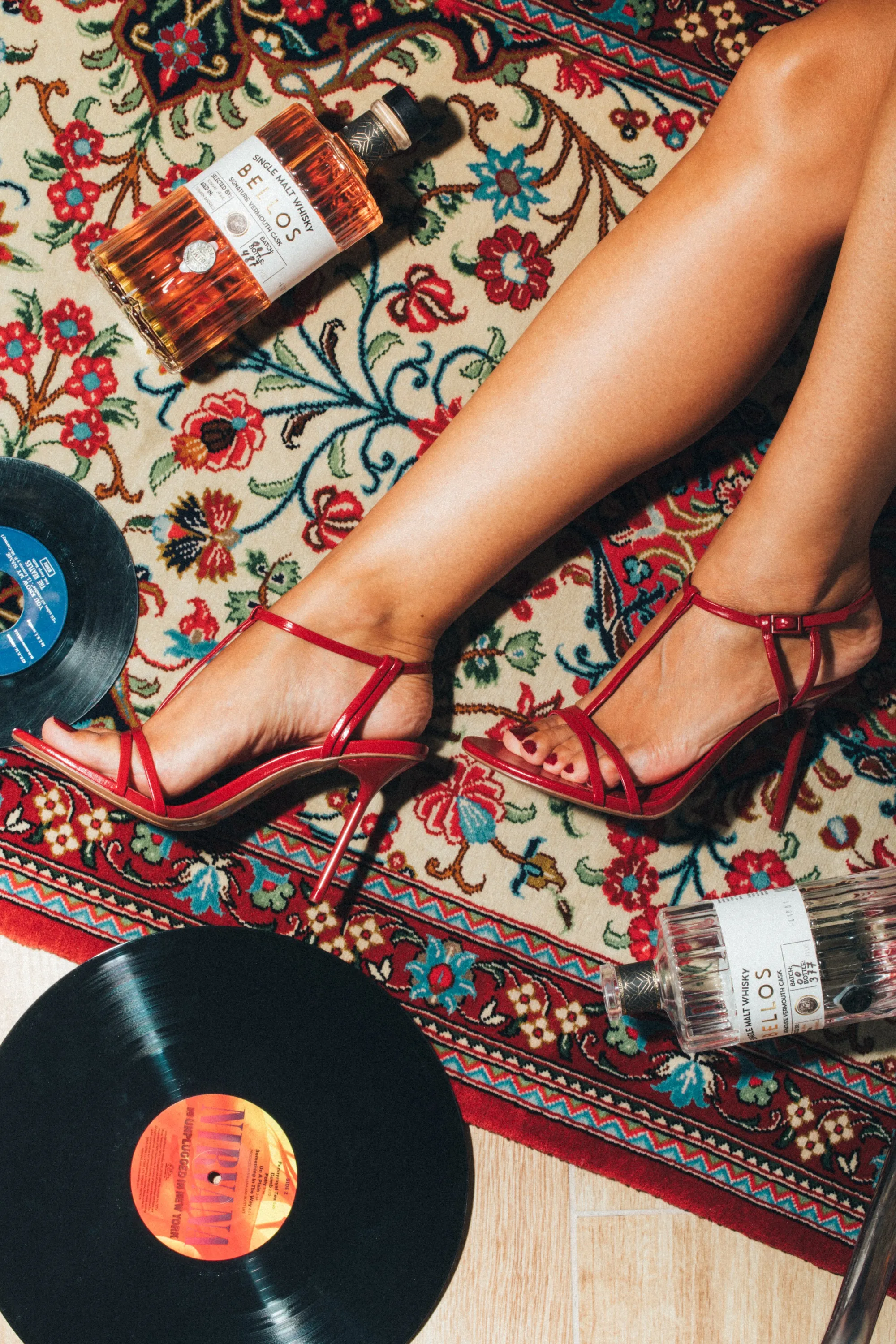 Bellos whisky con vinilos y tacones rojos