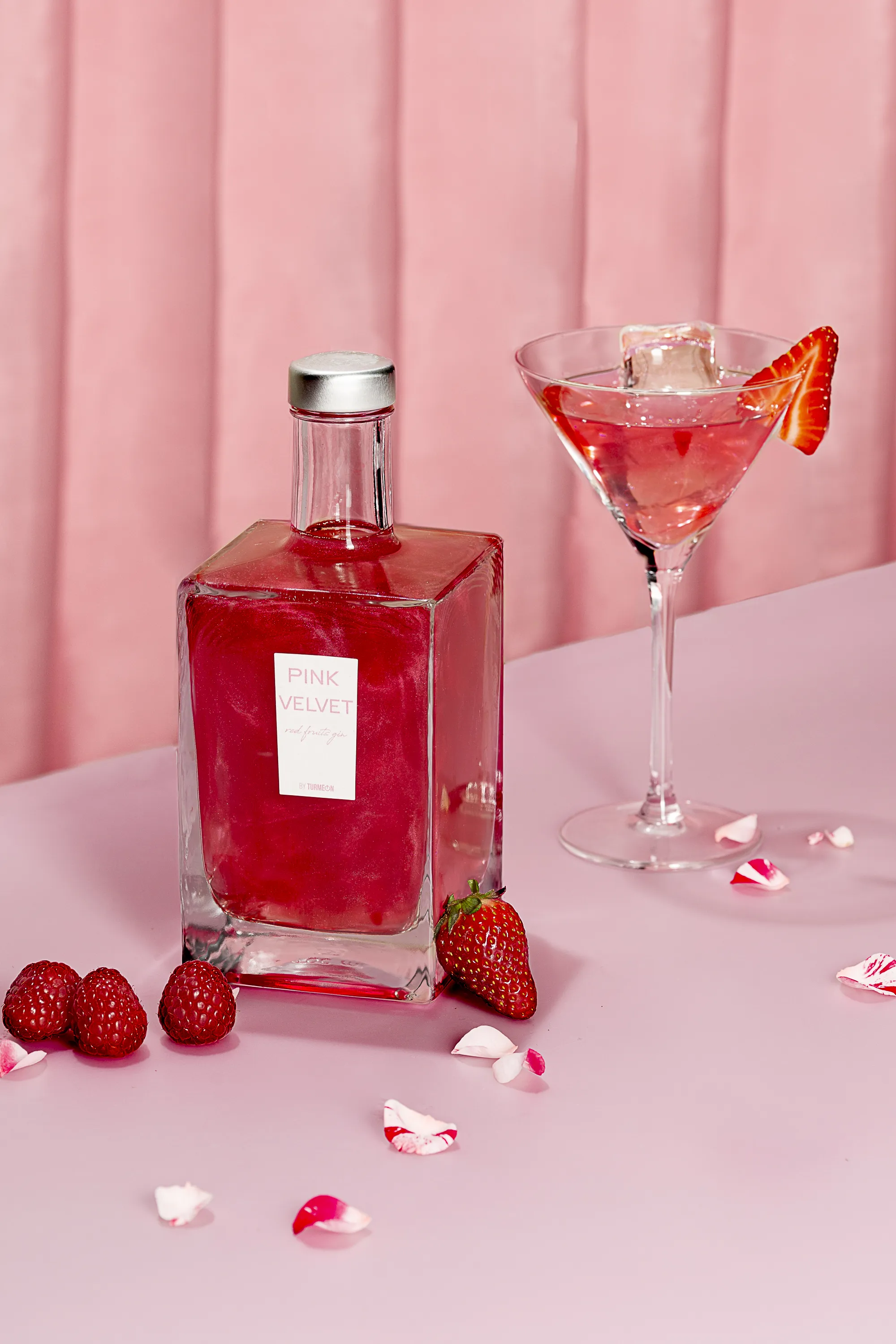 Botella de Pink Velvet con frambuesas en bodegón